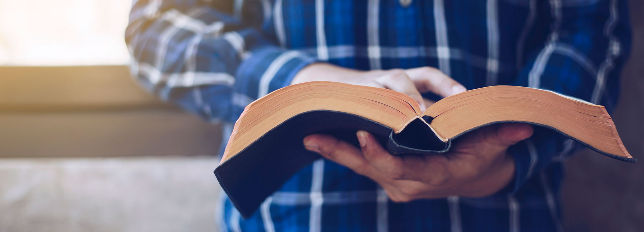 Photo image of young man reading a Bible.